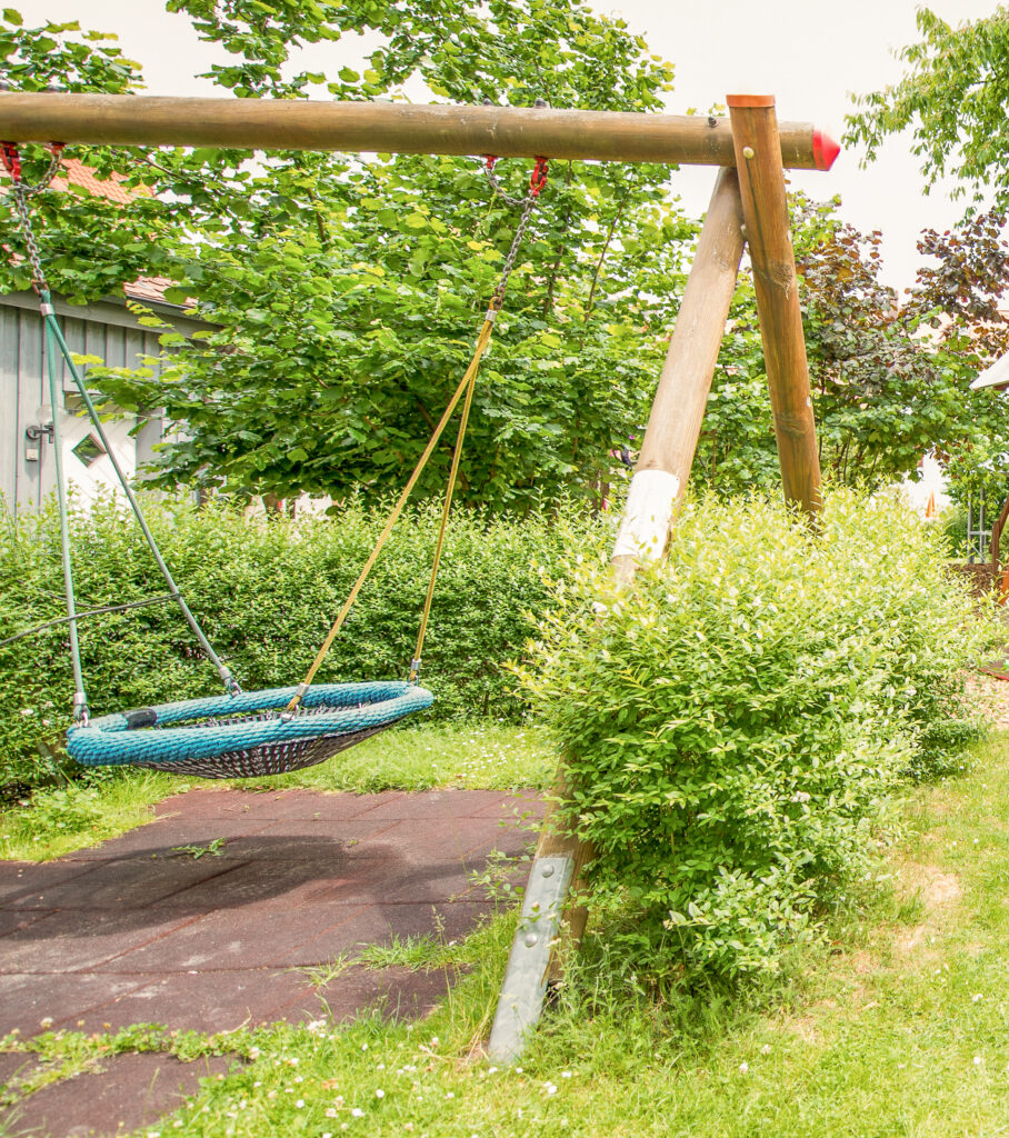Nestschaukel zwischen Bäumen im Außengelände des Integrativen Montessori Kindergartens Bayreuth