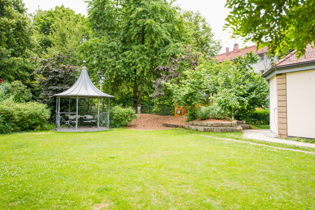 Großzügige Spielwiese mit Pavillon vor dem Integrativen Montessori Kindergarten Bayreuth